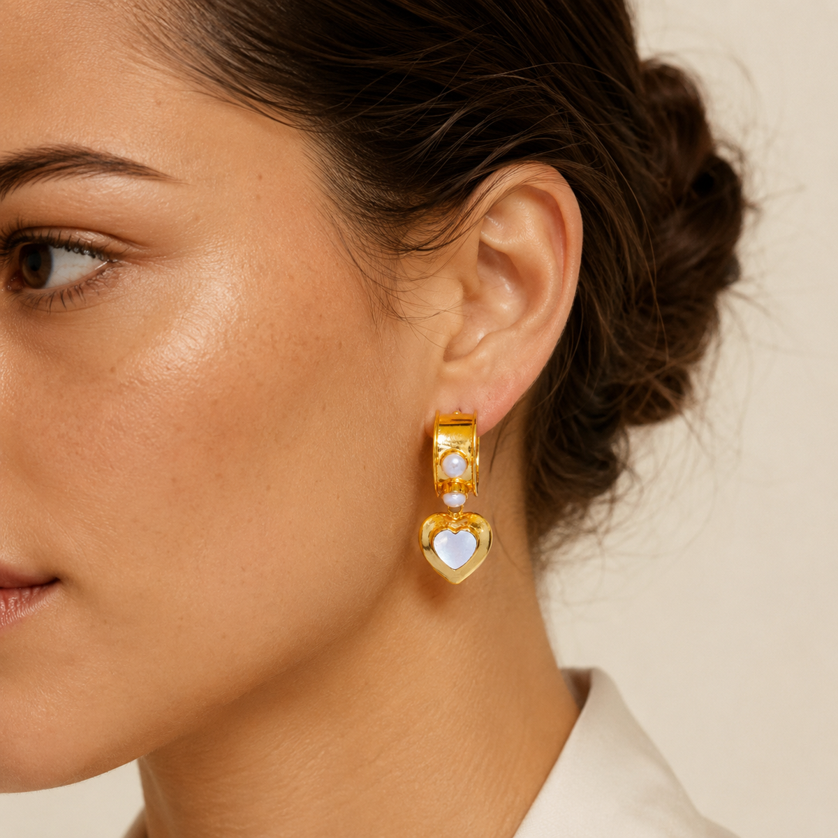 Gold-plated drop earrings with mother of pearl heart charms shown front view.