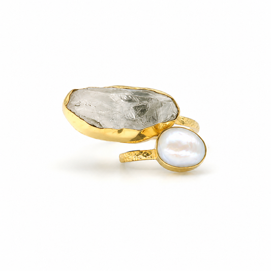 Gold-plated ring with a clear quartz stone and pearl-like accent on a white background.