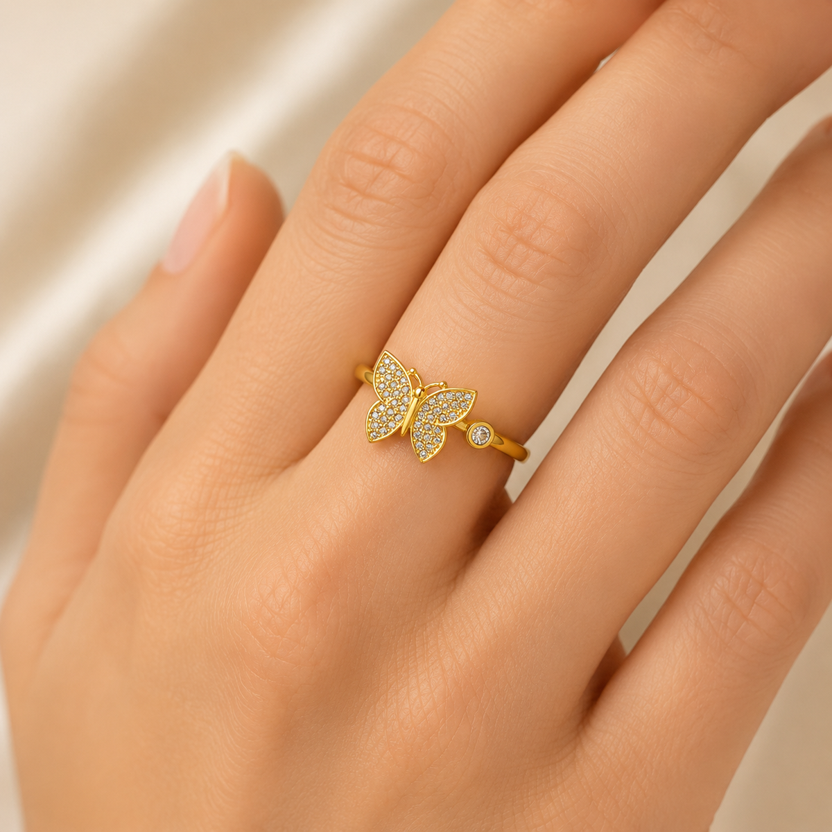 Gold-plated butterfly ring with clear CZ details on a white background.