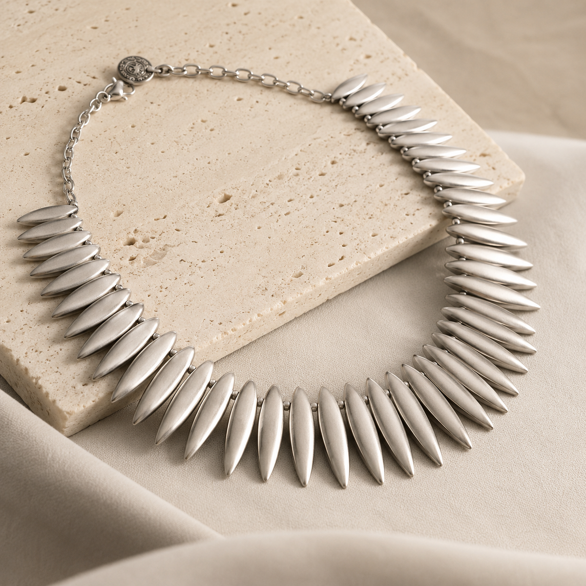 Angled view of the silver-tone collar necklace with leaf spike links.