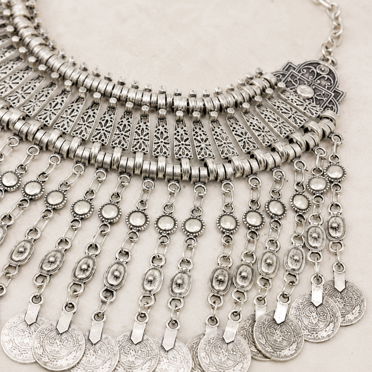 Close view of the necklace showing textured silver-tone links and cutout metal accents.