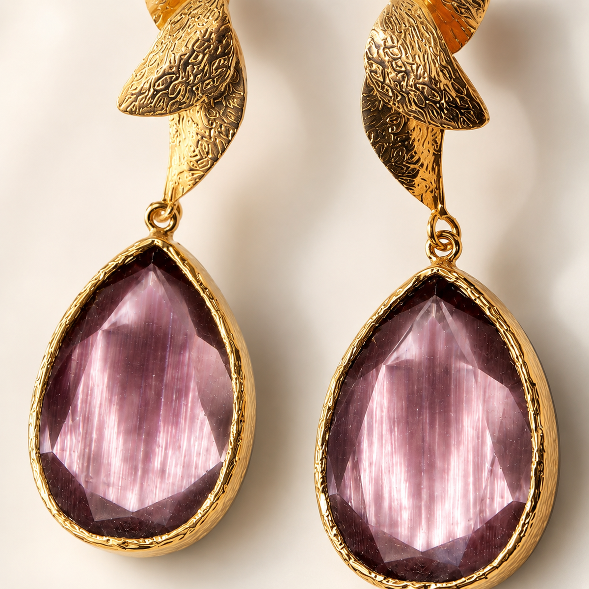 Close-up of purple tulip-inspired drop earrings with textured gold-plated detail.