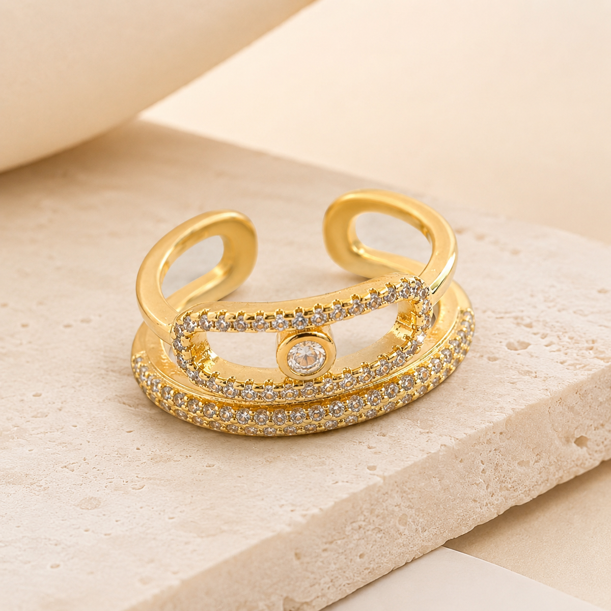 Angled view of a gold-tone triple band wrap ring with CZ details.