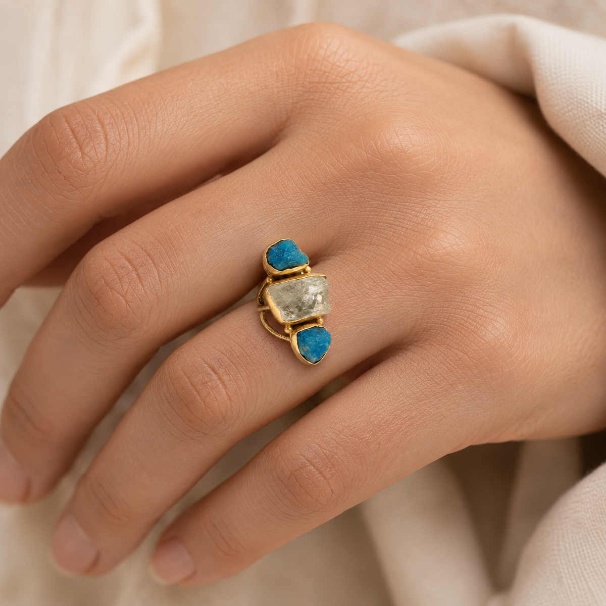 Gold-plated ring with a clear quartz center and blue apatite stones.