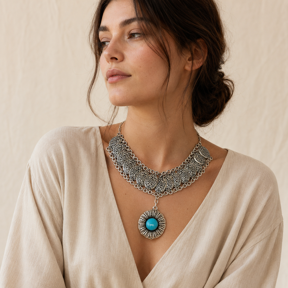 Ornate silver-tone necklace with a turquoise medallion pendant.
