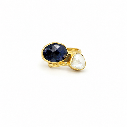 Gold-plated ring with a faceted navy blue crystal and a pearl-like white stone.