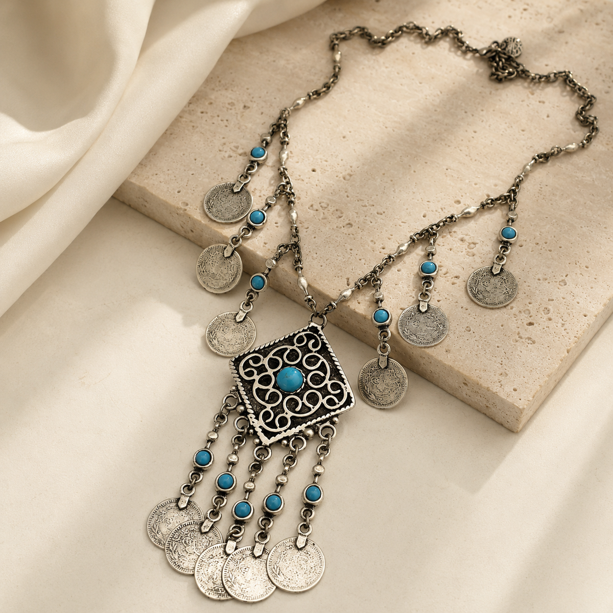 Silver necklace with turquoise accents, medallion coins, and a fringe pendant.