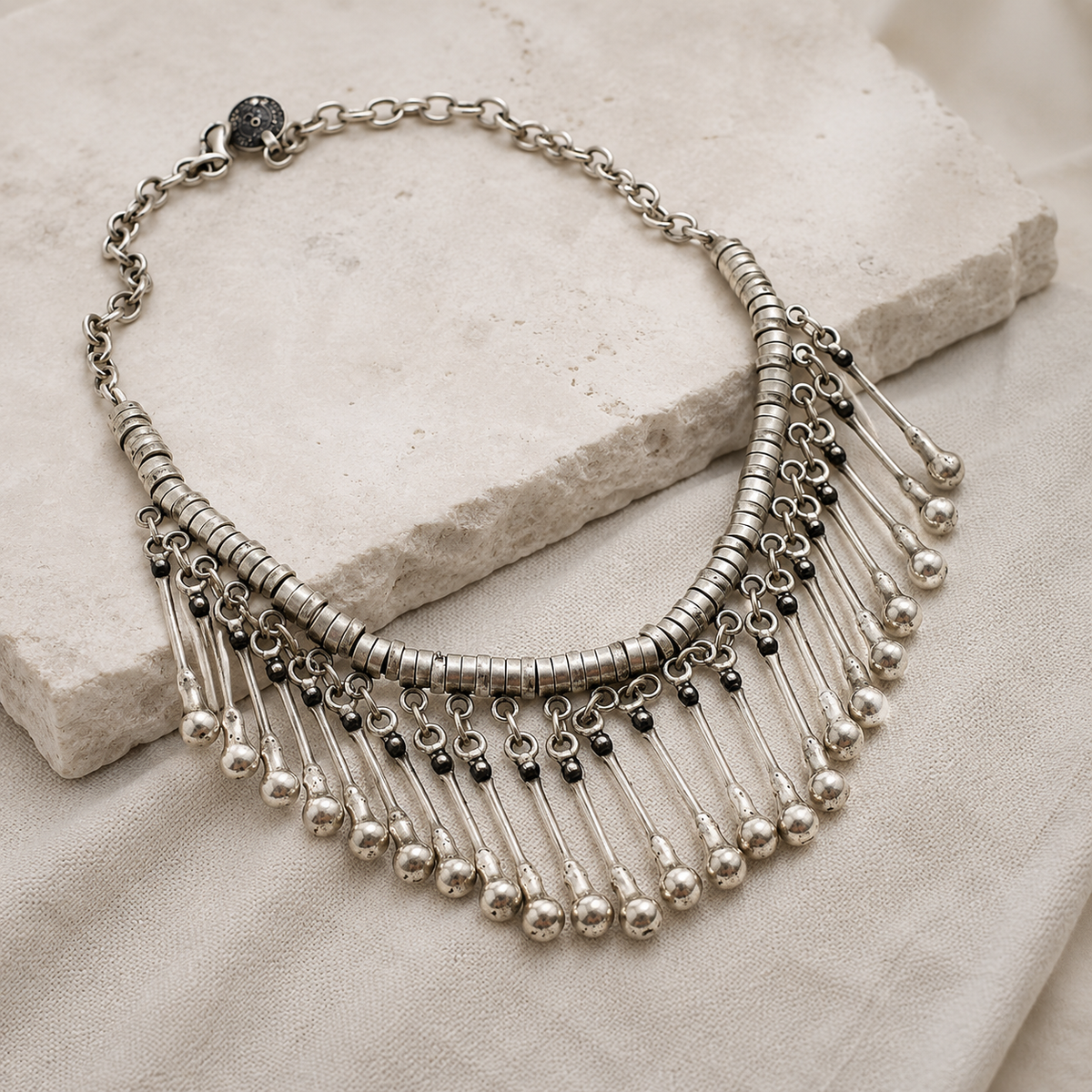 Angled view of a silver-tone drop fringe collar necklace.