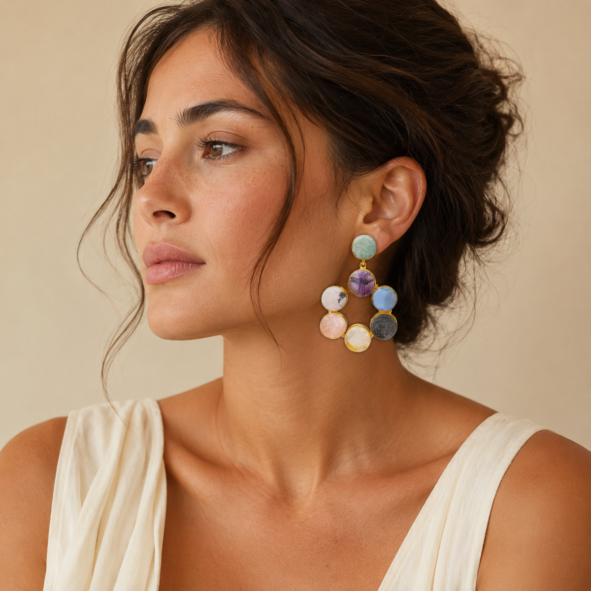 Gold-tone statement earrings with colorful round gemstone-style stones arranged in a hoop shape.