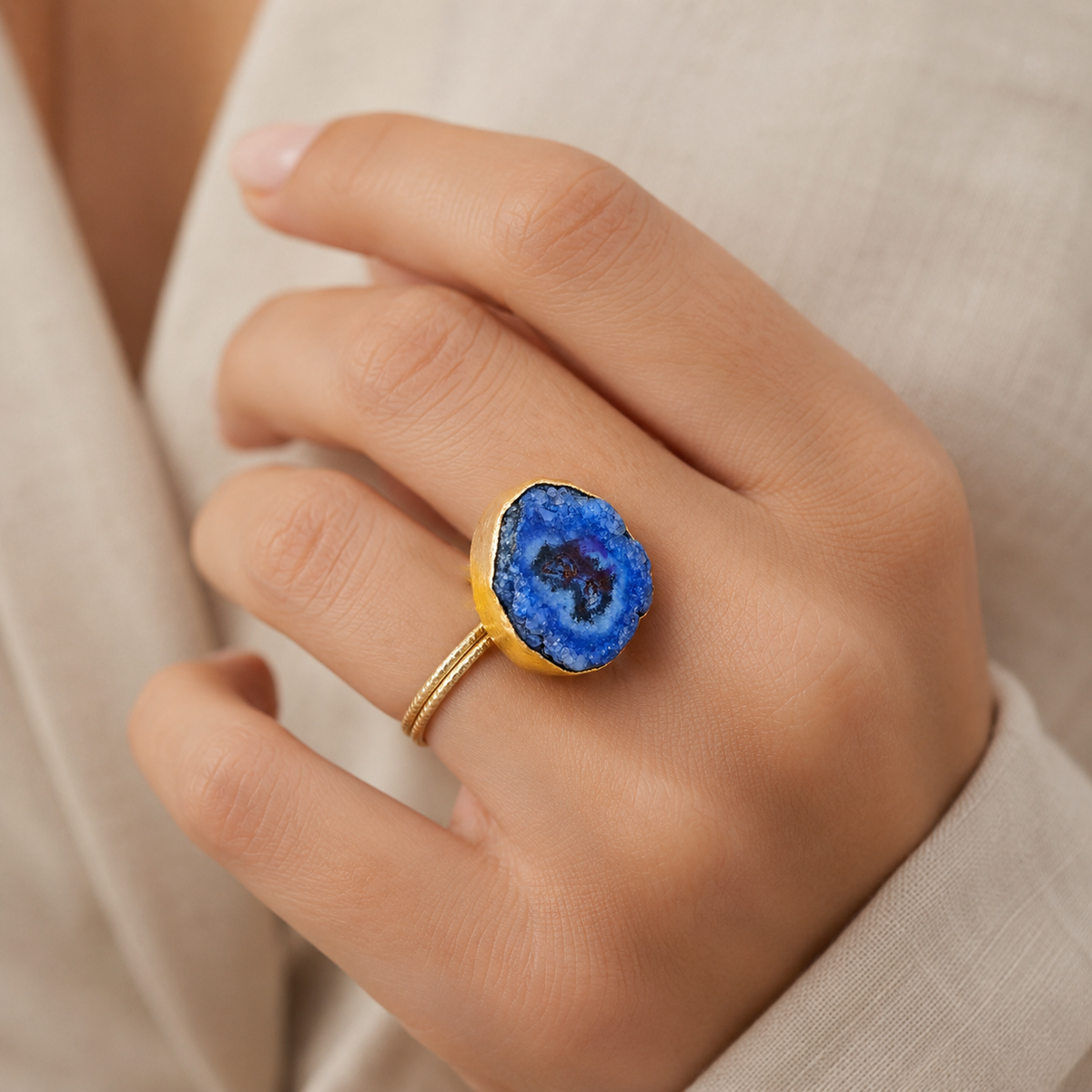 Blue druzy agate ring shown from a front angle with a gold-tone band.