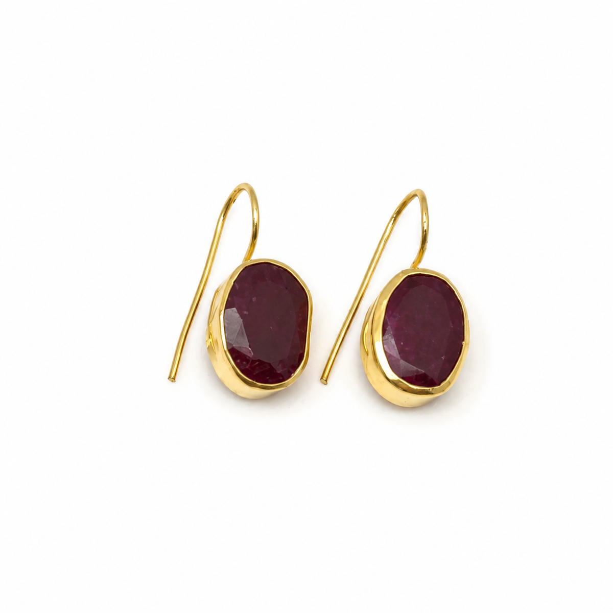 Gold-plated drop earrings with oval deep red stones.