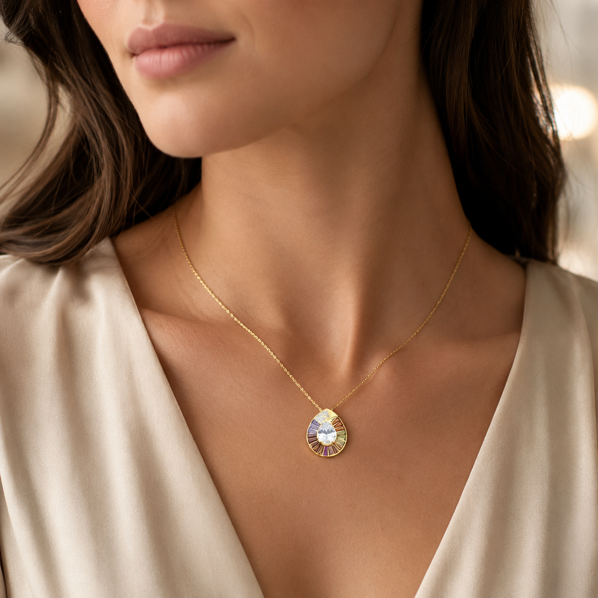 Rainbow CZ pendant necklace with a teardrop silhouette and polished gold-tone finish.