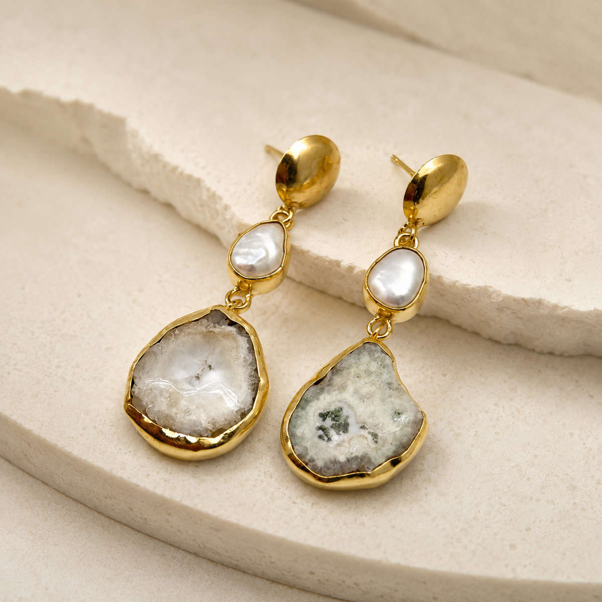 Angle view of gold-plated baroque pearl-inspired drop earrings with irregular pendants.