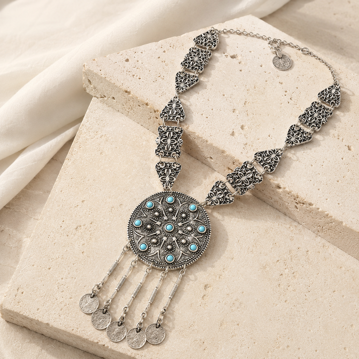 Silver-tone pendant necklace with a bold decorative silhouette.
