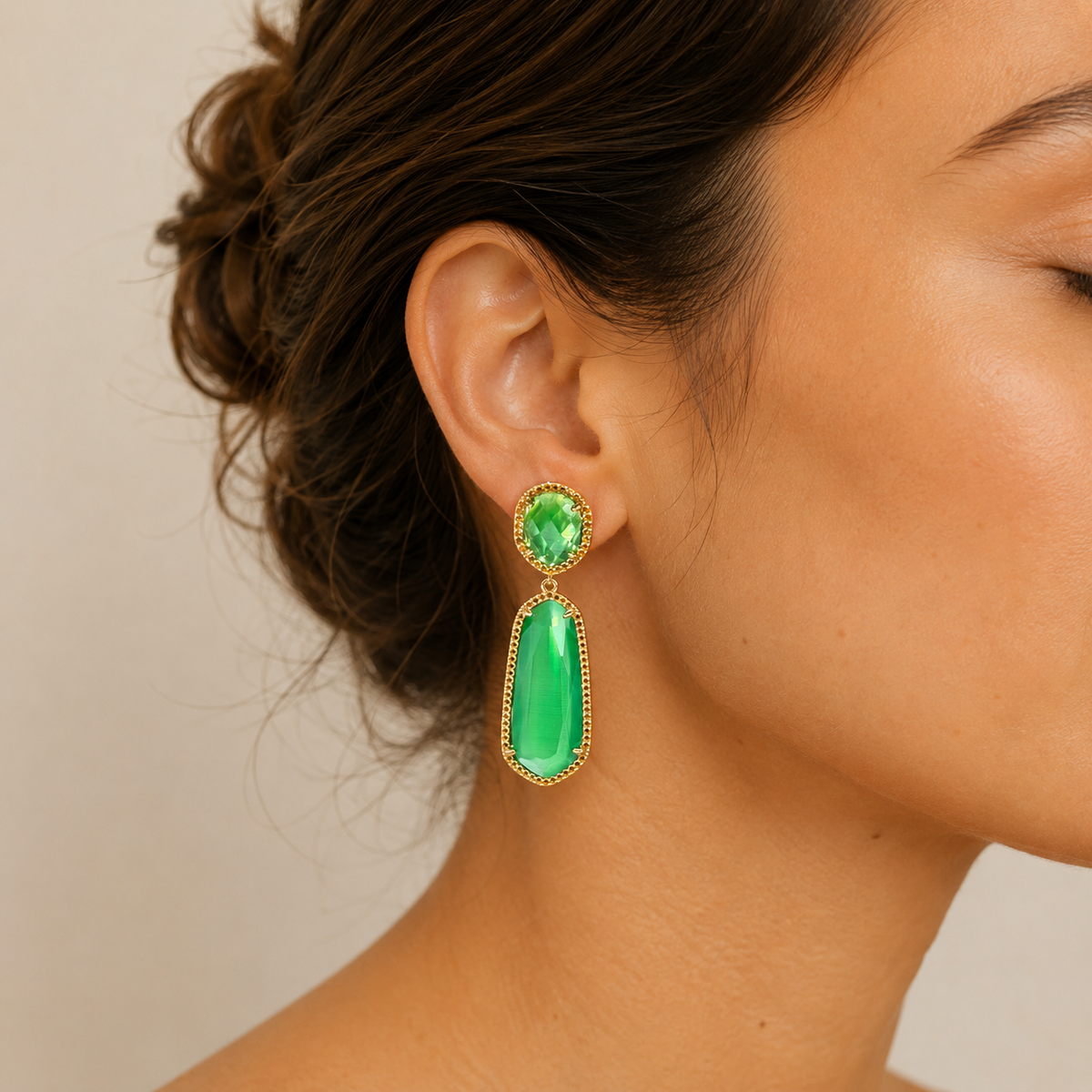 Emerald green statement drop earrings with a polished gold-plated frame.