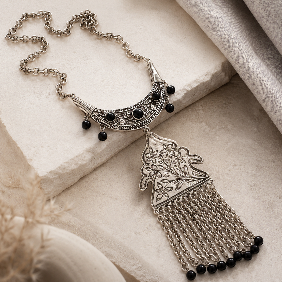 Angled view of the floral chain tassel pendant necklace.