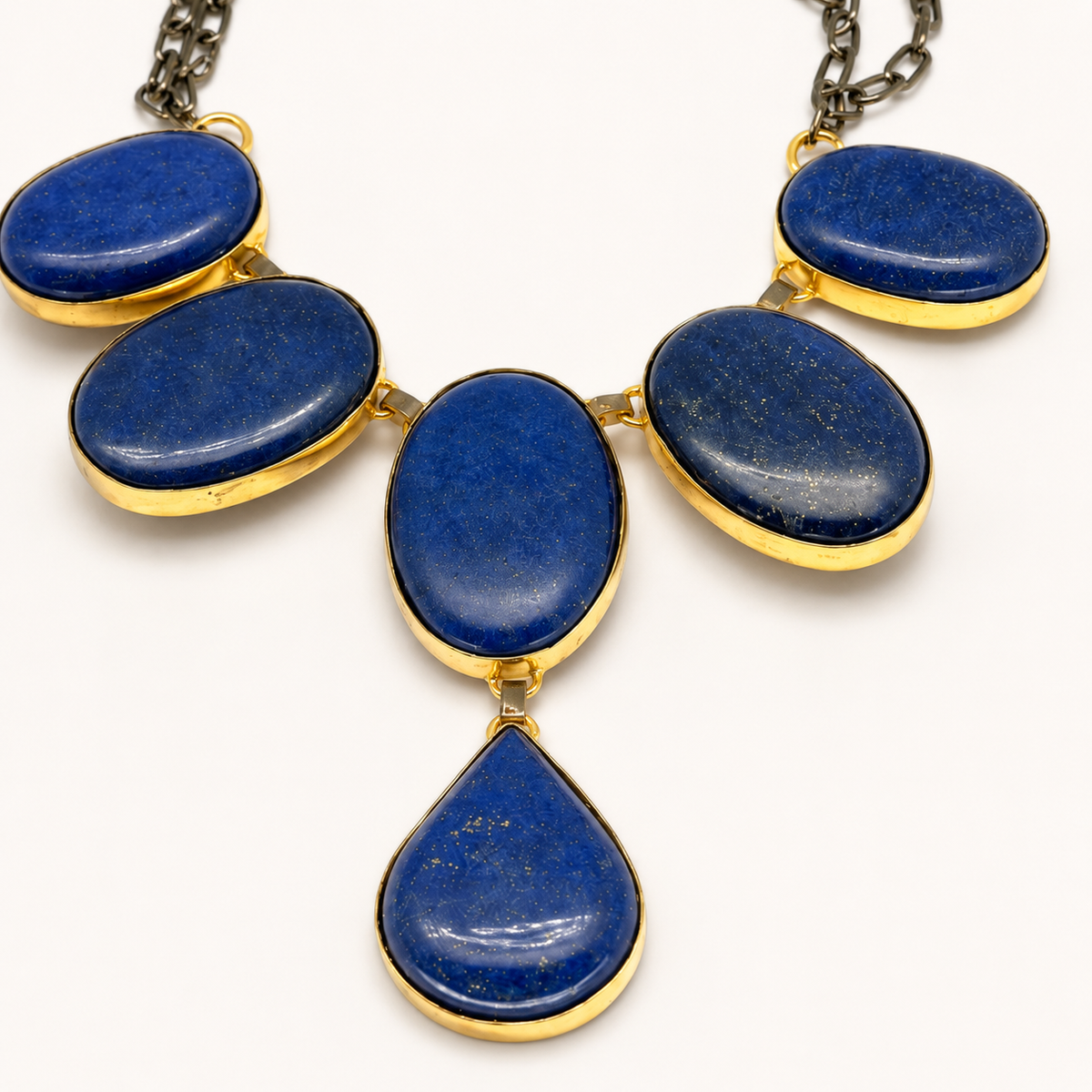 Close view of blue oval stone-style accents framed in gold-tone metal.