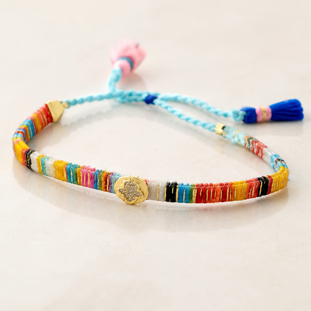 Close view of the multicolor thread-wrapped bracelet with gold-tone details.