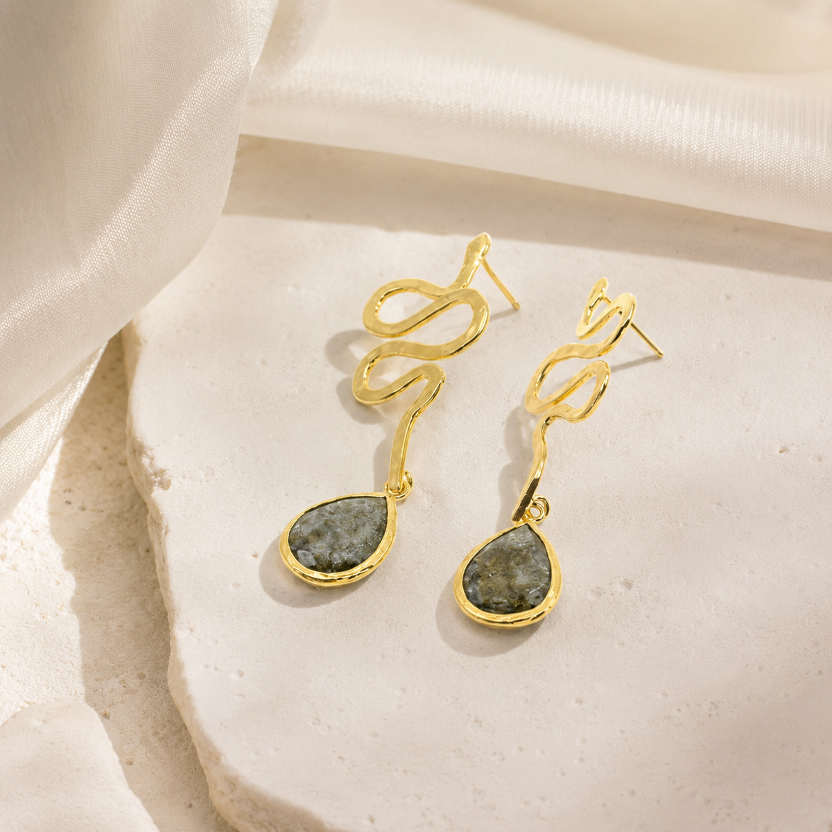 Gold snake drop earrings with a fluid curved silhouette.