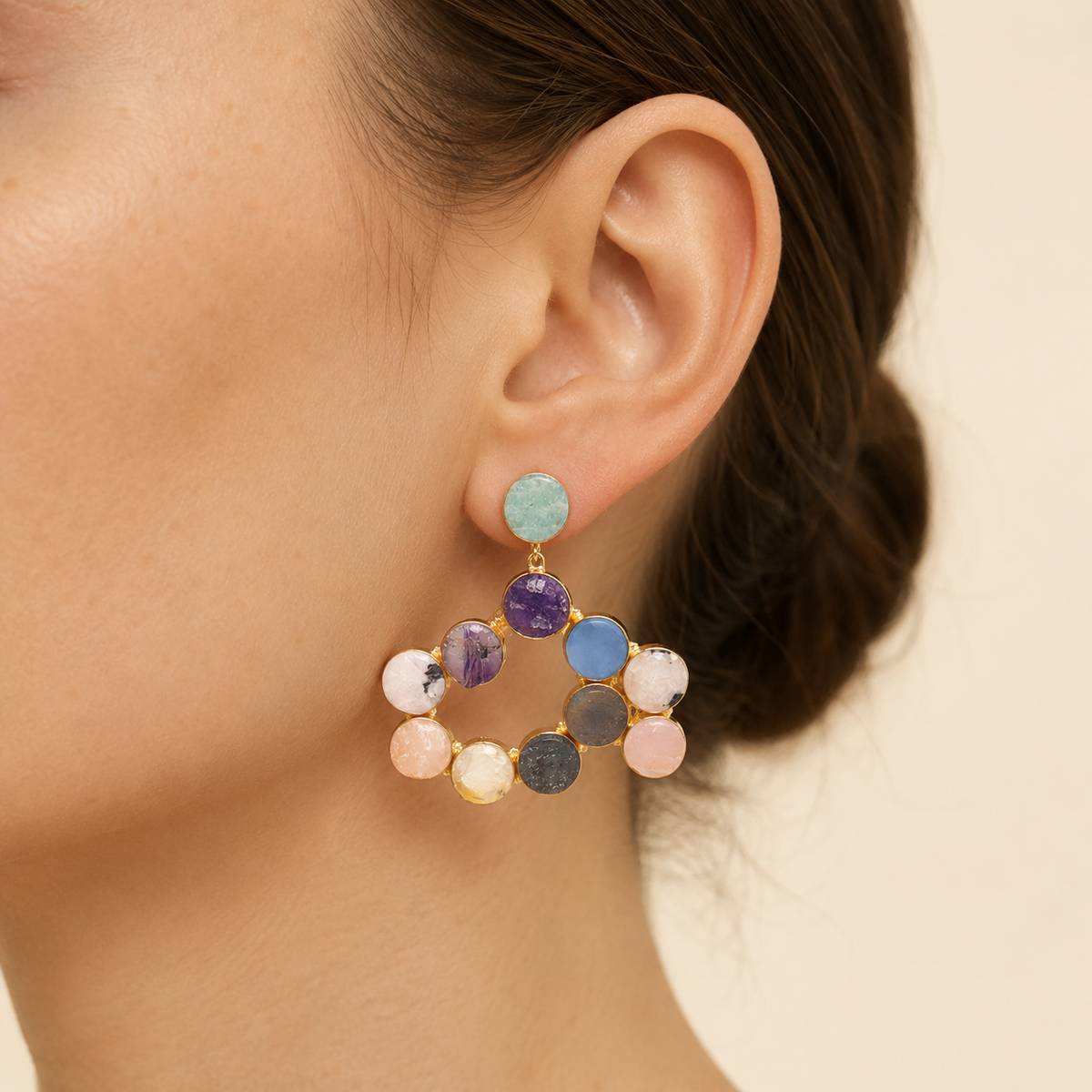 Gold-tone statement earrings with colorful round gemstone-style stones arranged in a hoop shape.