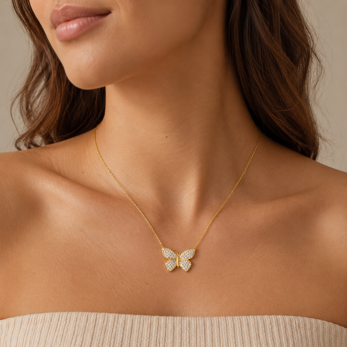 Gold-tone butterfly pendant necklace shown against a white background.