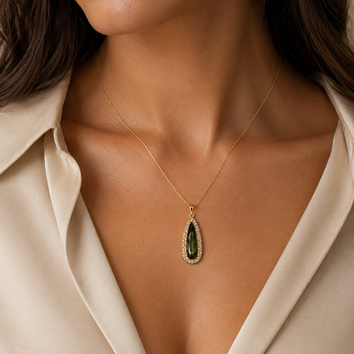 Gold-tone teardrop pendant necklace shown on a white background.