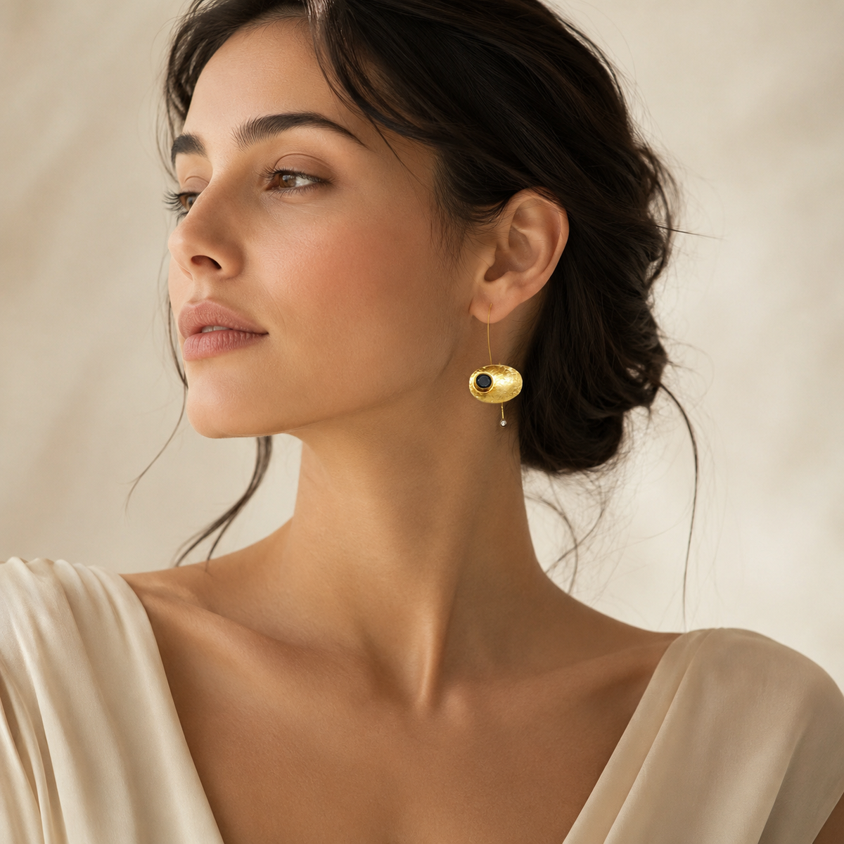 Gold-plated drop earrings with oval shapes and black stone details.