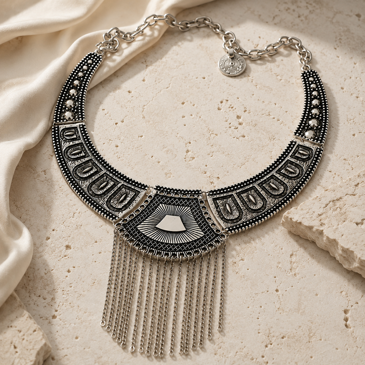 Black geometric necklace with a sculptural shape and dangling chain fringe.