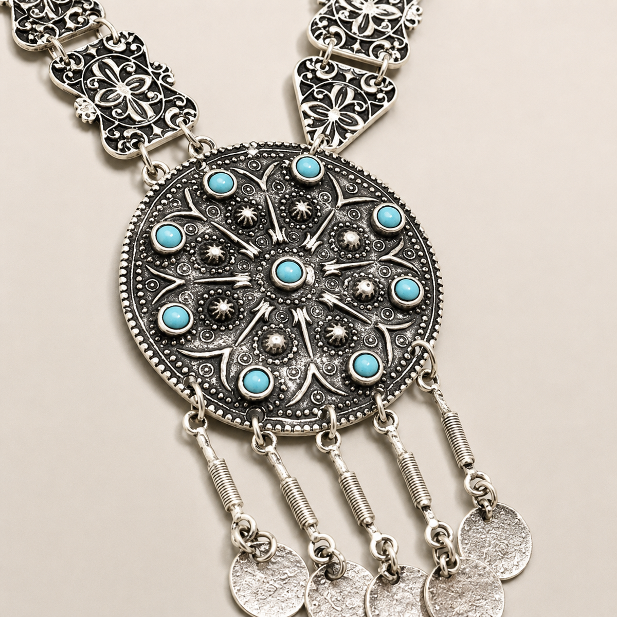 Close view of the turquoise accents and textured coin-inspired pendant.