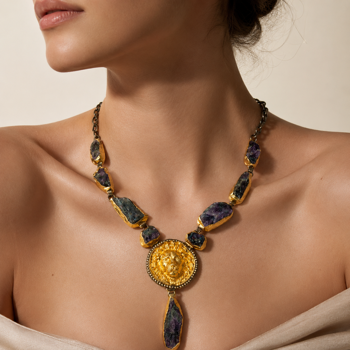 Purple raw stone statement necklace with a gold-tone sunburst pendant.