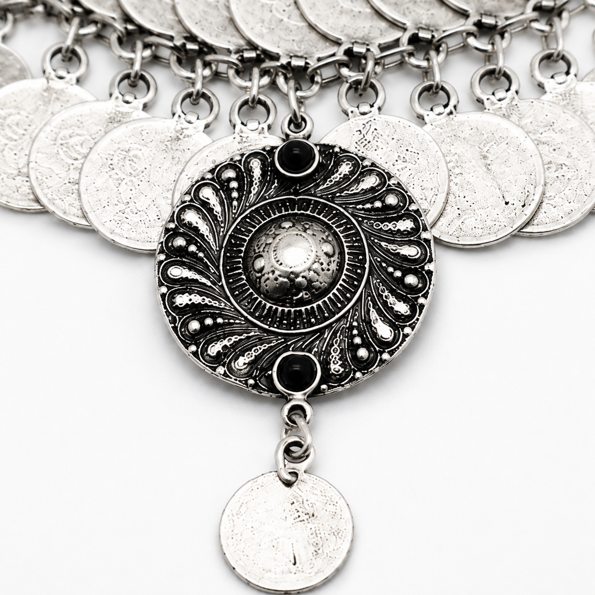 Close view of the textured coin discs and dark center pendant.
