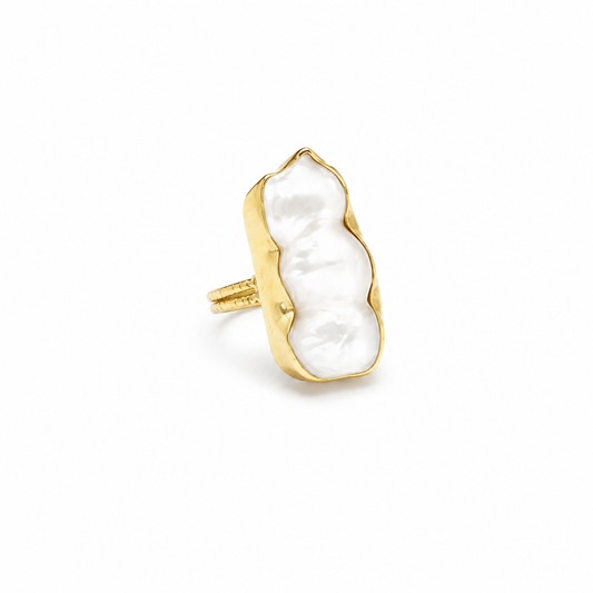 A baroque pearl statement ring with a gold-plated frame and sculptural silhouette.