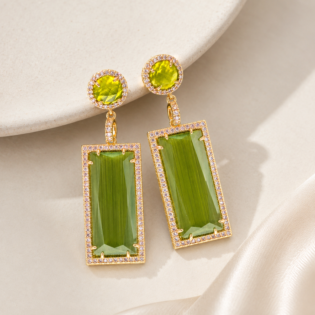 Pair of olive green and gold-plated drop earrings on a white background.