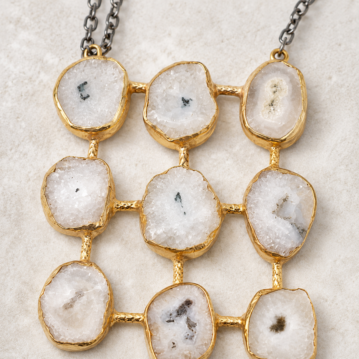 Close view of the gold-tone frame and stone grid pendant.