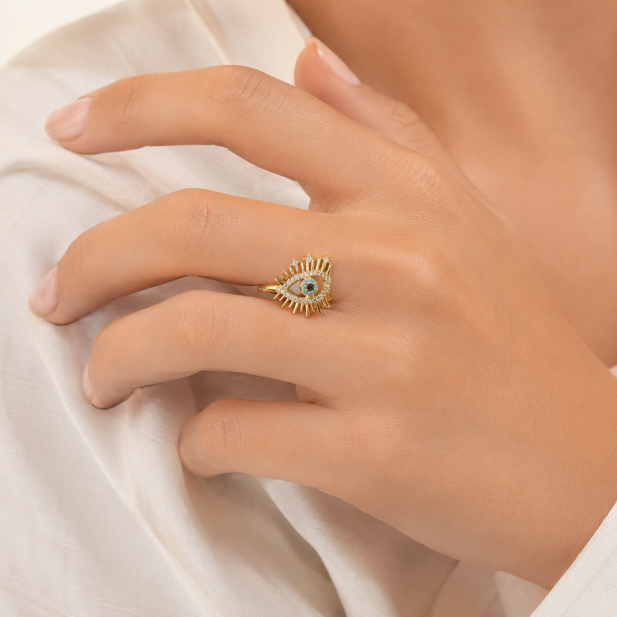 Gold-tone evil eye ring shown from the side with a bold open silhouette.