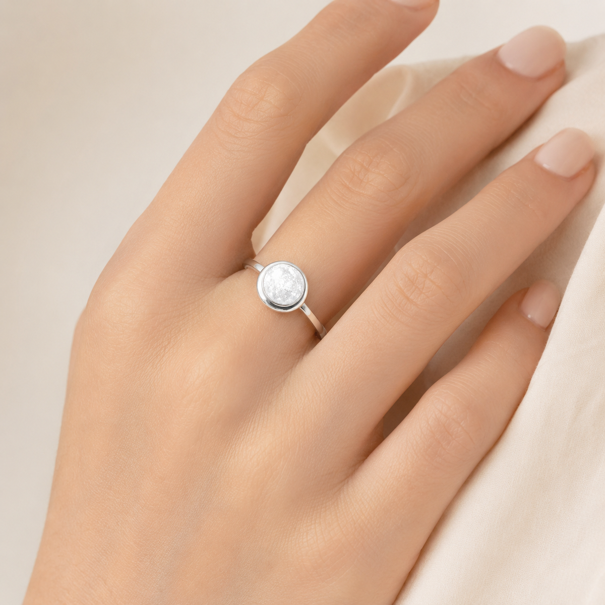 Silver-tone bezel ring with a clear textured stone center.