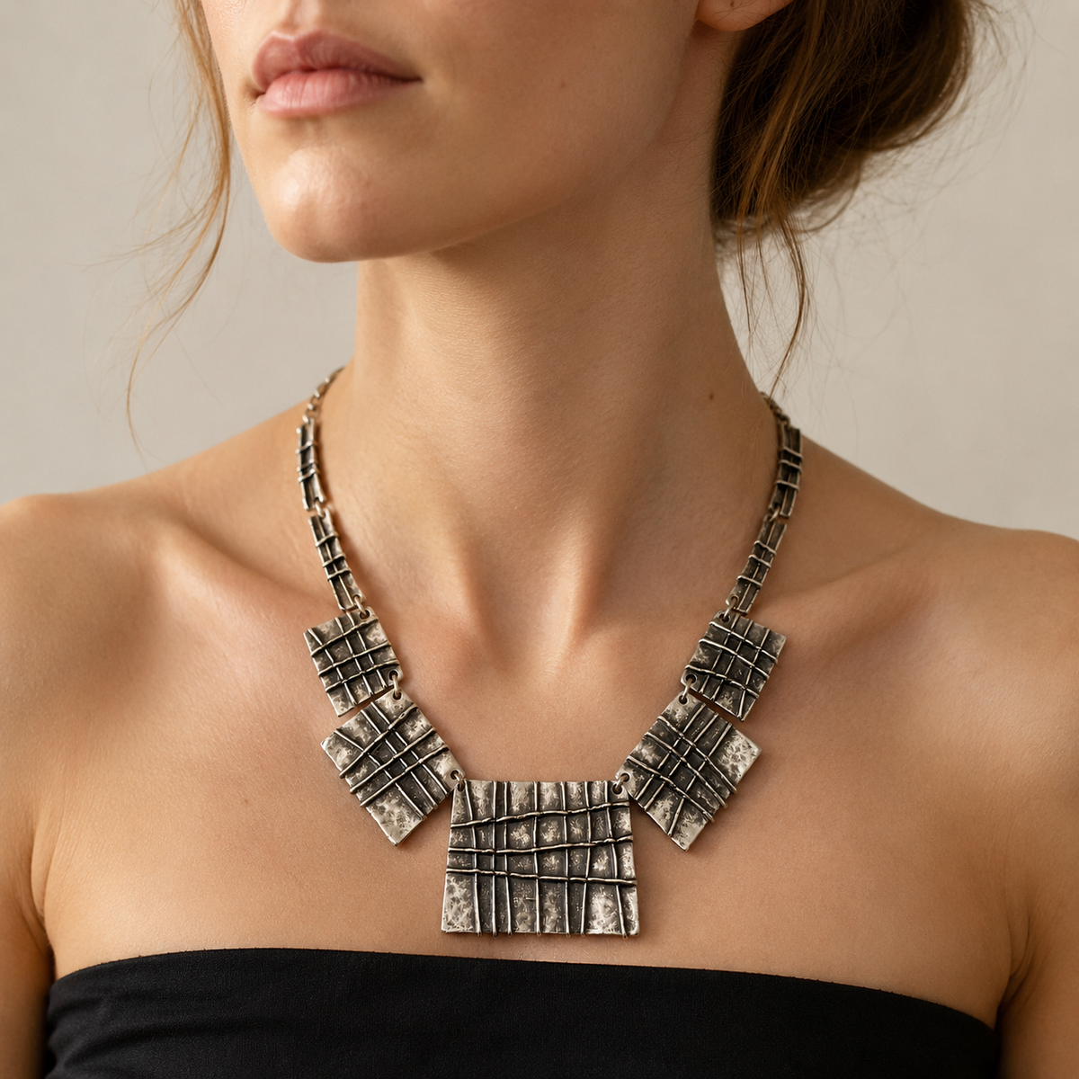 Silver-tone statement necklace shown on a white background.