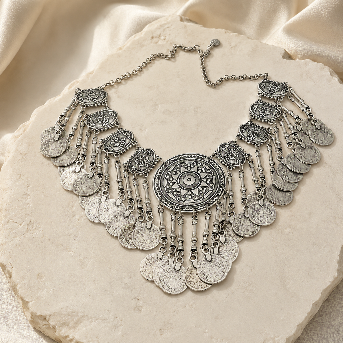 Close view of the detailed medallion and coin fringe necklace.