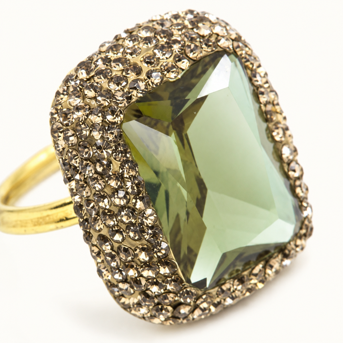 Close view of a textured gold-tone ring with a faceted color-changing stone.