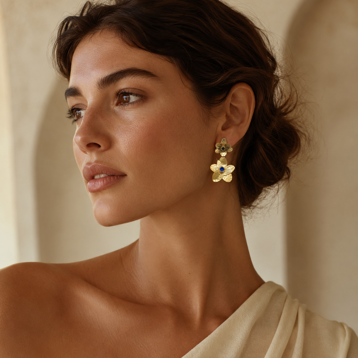 Pair of gold-plated floral drop earrings with blue stone accents.