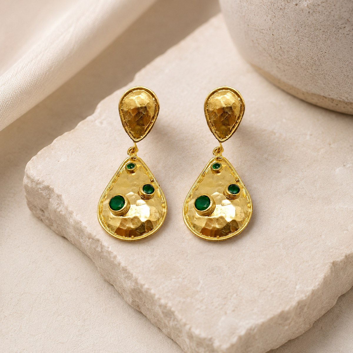 Gold-plated double drop earrings with a hammered finish and green stones.