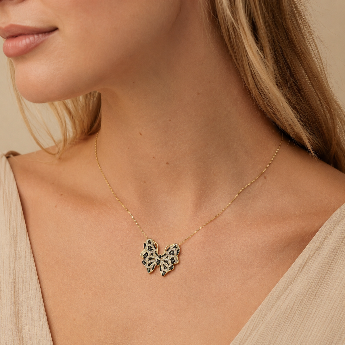 Gold-tone butterfly pendant necklace with black and clear detailing.