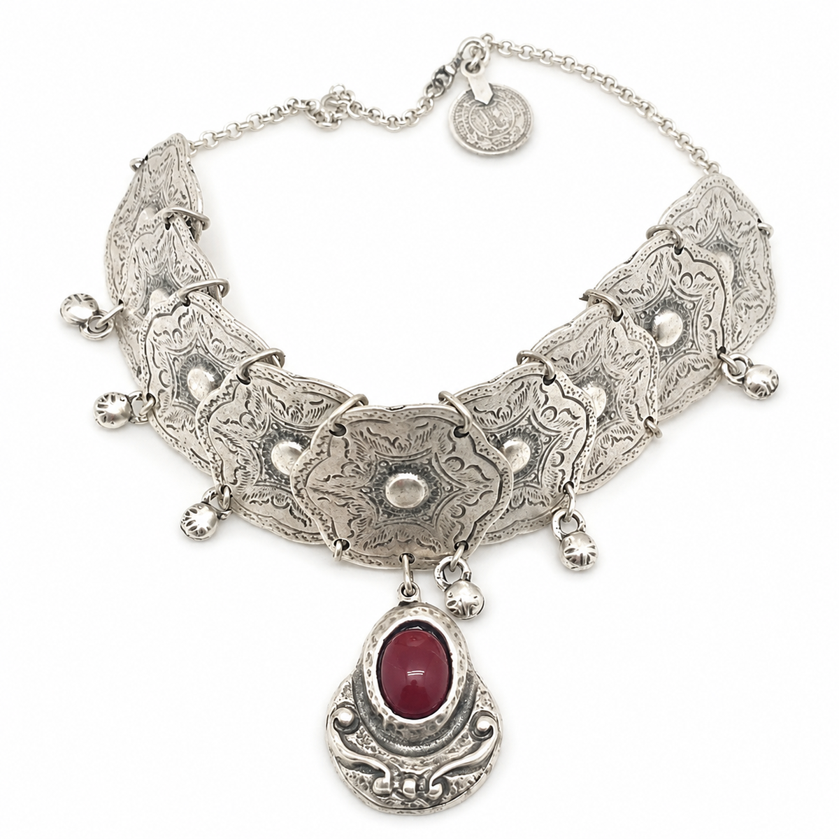 Silver-tone choker necklace with engraved plates and a red stone pendant.