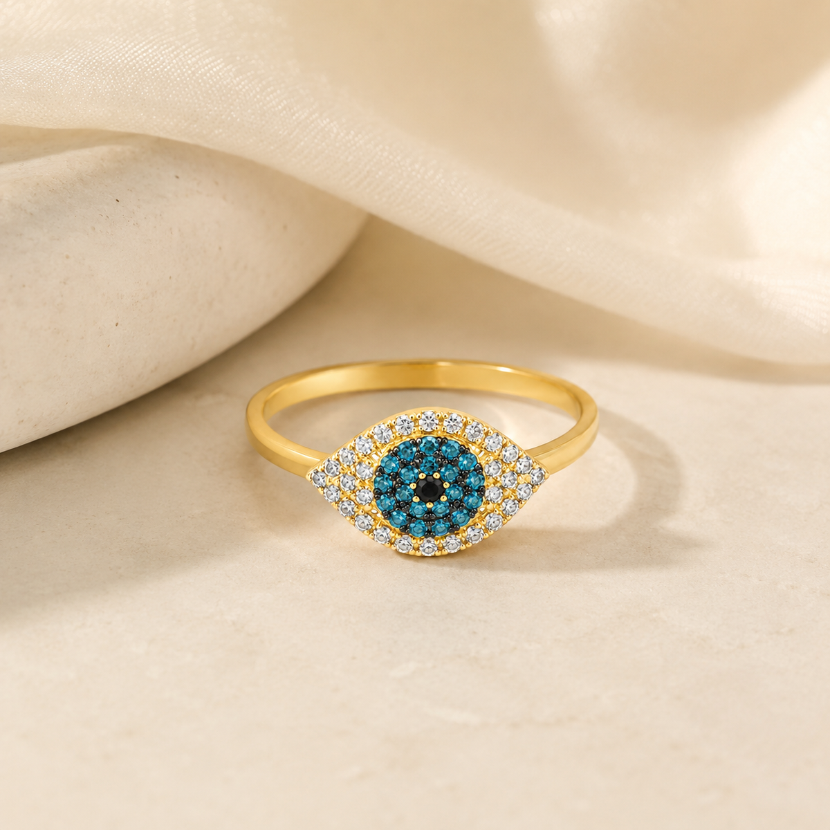 Gold-tone ring with an evil eye design and blue center.