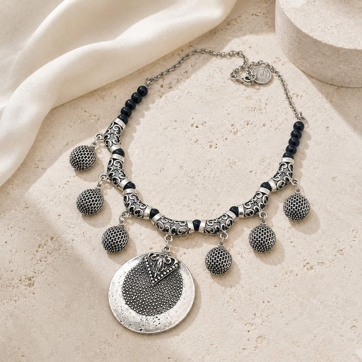 Black bead pendant necklace with silver-toned textured accents.
