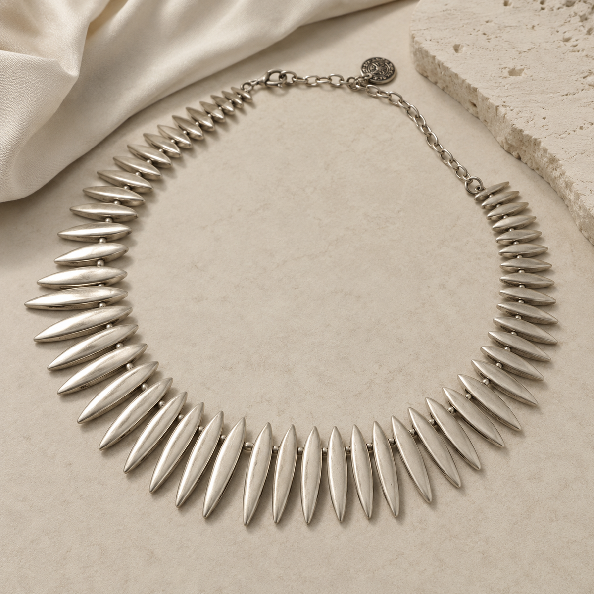 Silver-tone sculptural collar necklace with pointed leaf-like links.