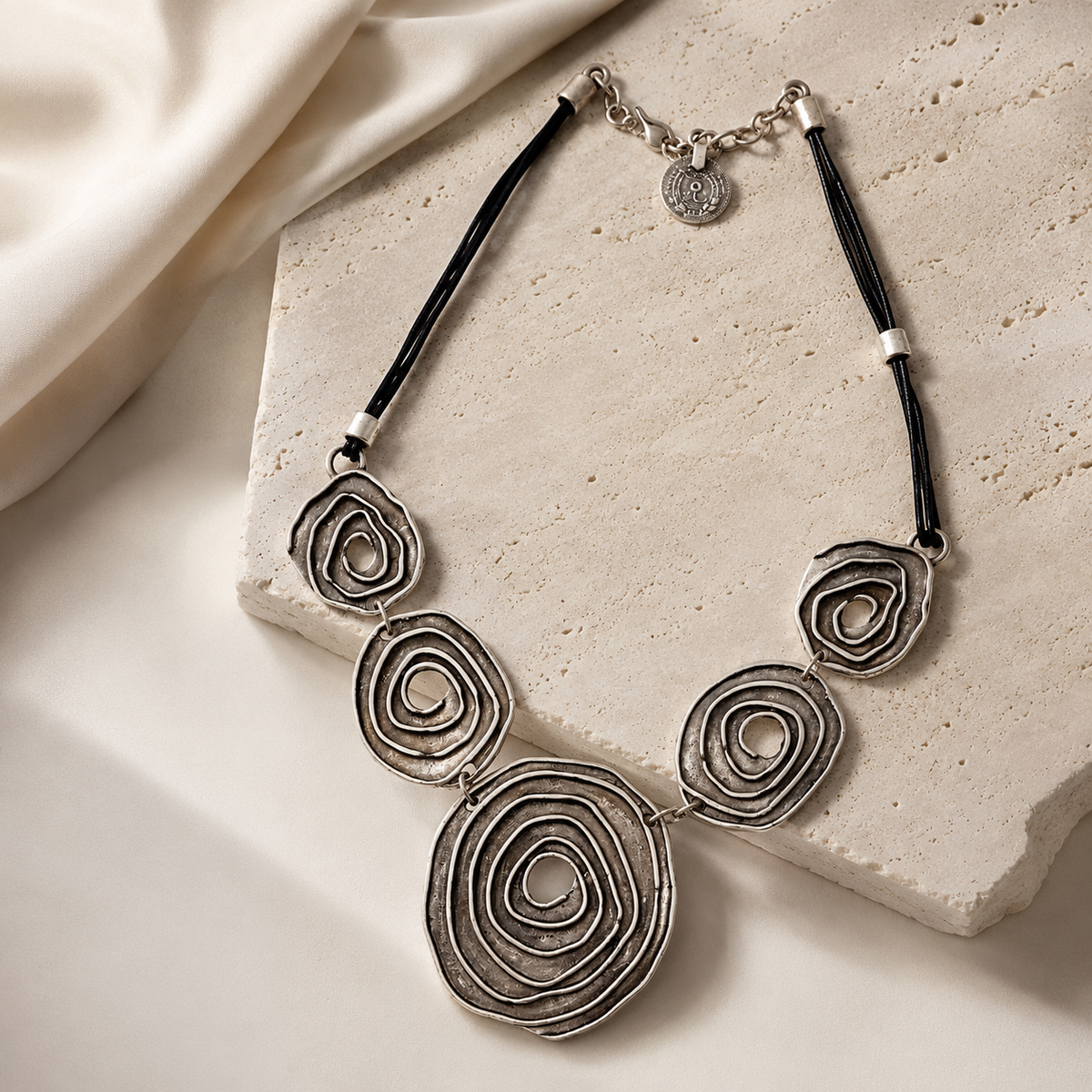 Black cord necklace with sculptural spiral pendants for modern styling.