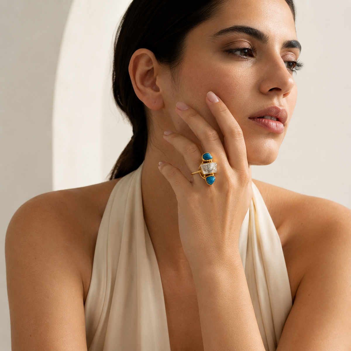Three-stone ring with blue apatite accents and a clear center stone.
