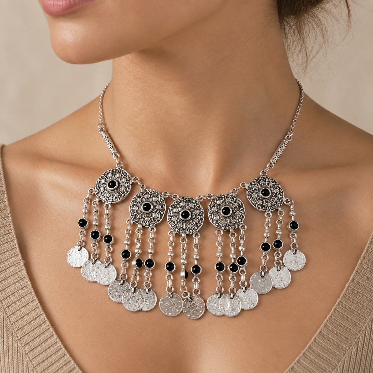 Silver-tone necklace with black stone accents and dangling coin fringe.
