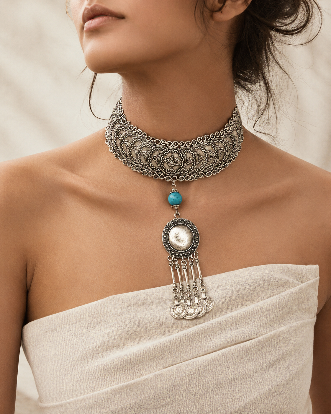 Front view of a silver-tone choker necklace with coin details and dangling charms.